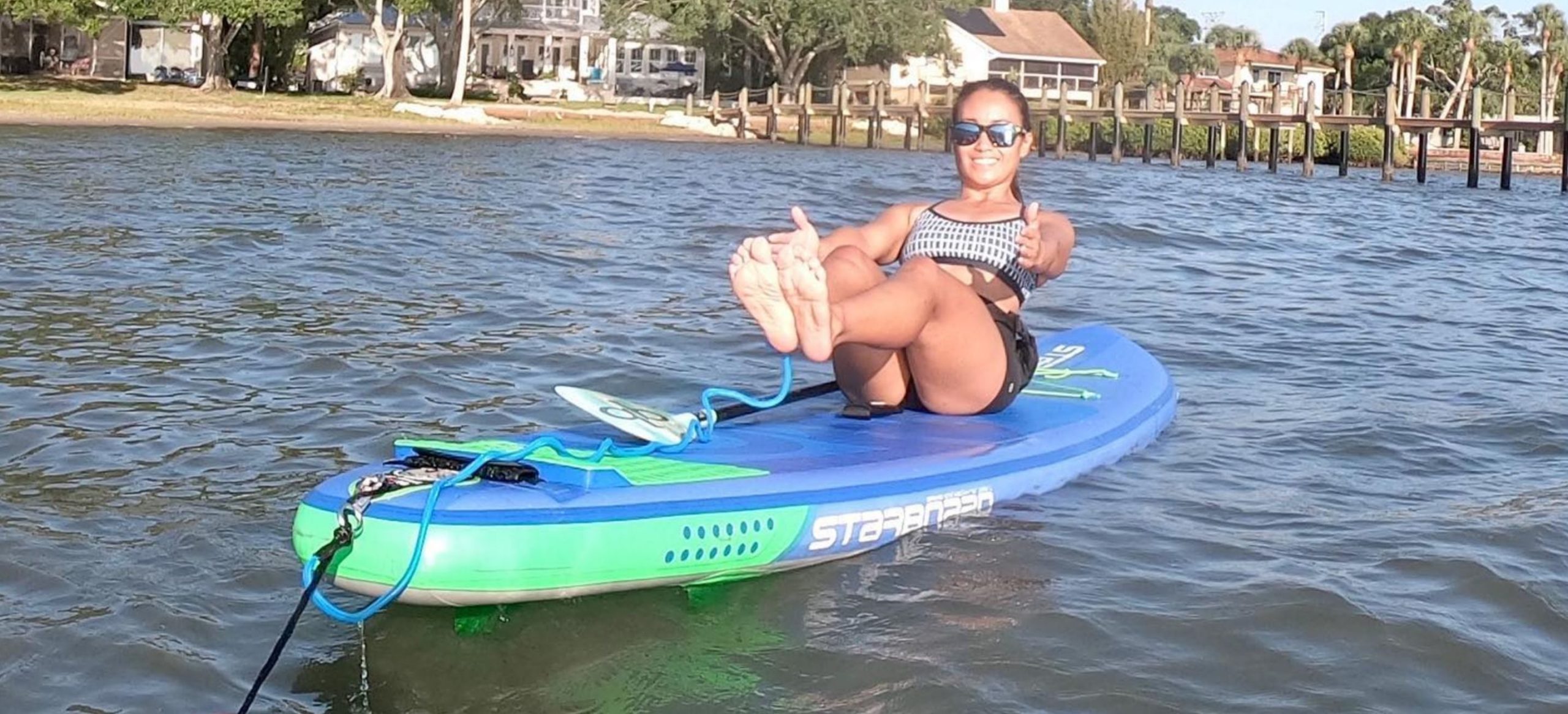 daffodil in boat pose on paddleboard